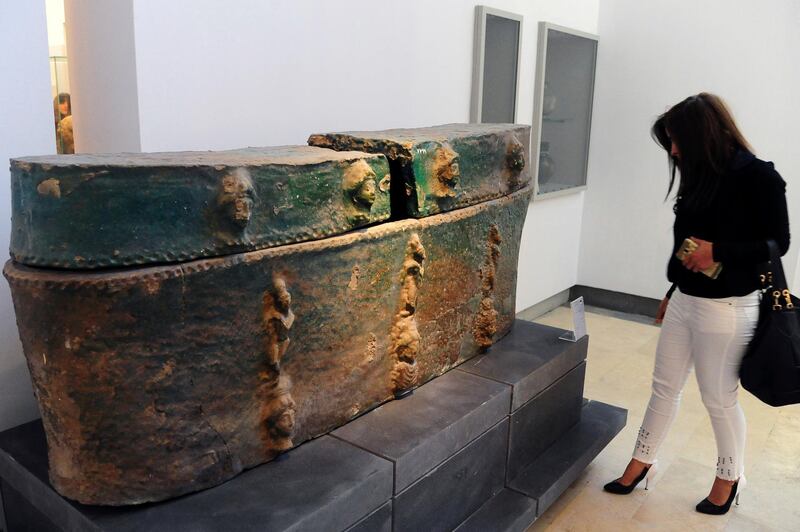 In this photo released by the Syrian official news agency SANA, a visitor looks at ancient artifacts during the reopening ceremony for Syria's National Museum, in Damascus, Syria, Sunday, Oct. 28, 2018. Syrian officials, foreign archeologists and restoration specialists attended the Sunday reopening ceremony in the heart of Damascus more than six years after the prominent institution was shut down and emptied as the country's civil war encroached on the capital. (SANA via AP)