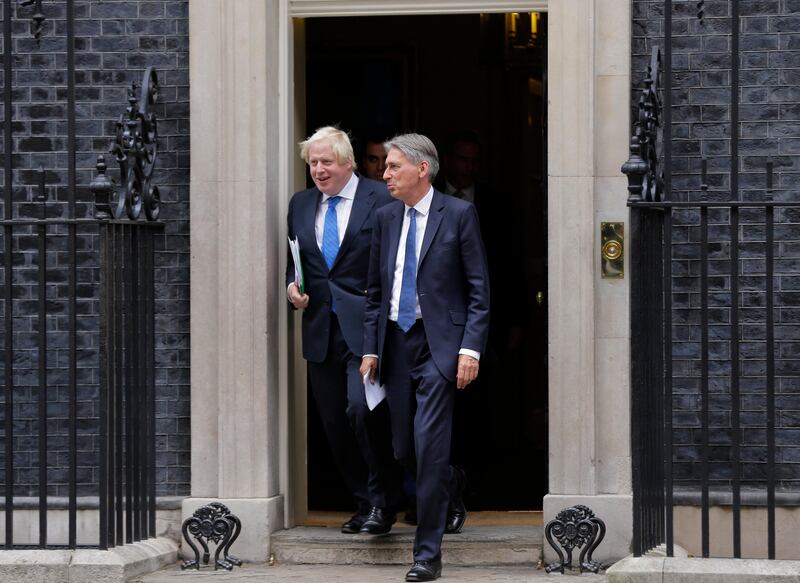 Britain Chancellor of the Exchequer Philip Hammond, right, departs with the Foreign Secretary Boris Johnson after a Cabinet meeting at 10 Downing Street in London, Thursday, Sept. 21, 2017. Britain's Prime Minister Theresa May will give a speech on Britain ongoing negotiations about leaving the EU in Florence, Italy on Friday, and she will brief the cabinet on its contents Thursday. (AP Photo/Alastair Grant)