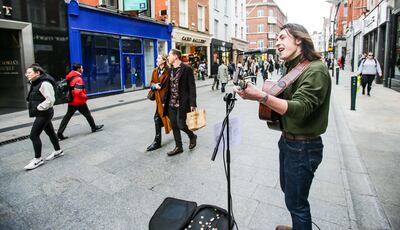 A busker plays to shoppers on Grafton Street in Dublin, Ireland. Picture date: Saturday January 22, 2022.