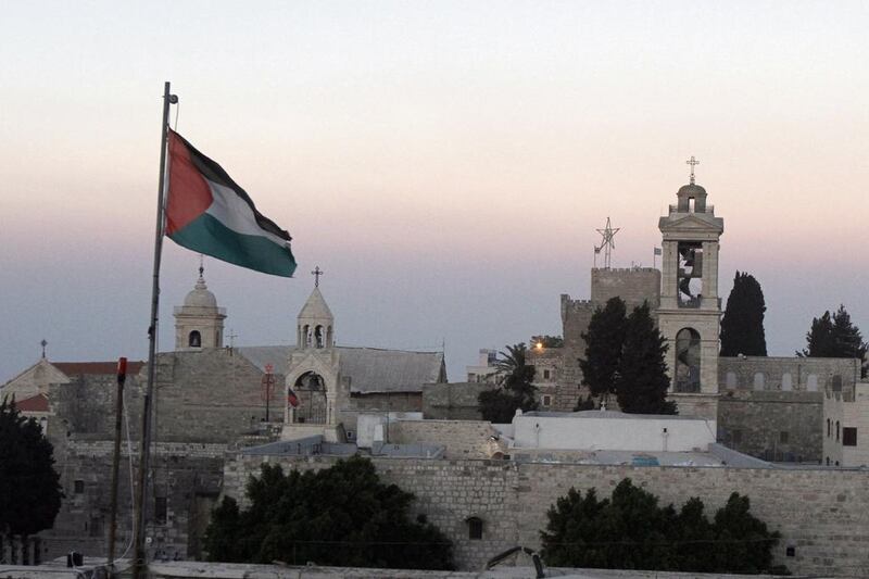 The Palestinian flag flutters in front of the Church of the Nativity in Bethlehem. Photo: Musa Al Shaer / AFP