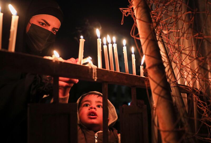 A child lights a candle as Shiite pilgrims gather to mark the birth anniversary of Imam Al Mahdi, in the Iraqi city of Karbala on March 28, 2021. Reuters