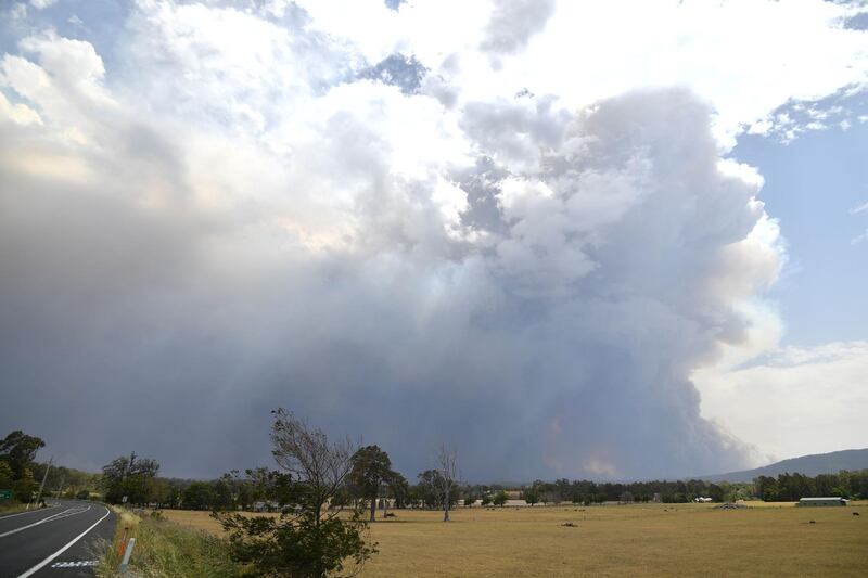 Smoke from bushfires rises high into the air as fires hit the area around the town of Nowra.AFP