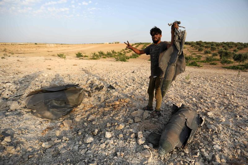 Rebel fighters gather near the remains of a downed regime warplane near the militant-held town of Khan Sheikhun. AFP