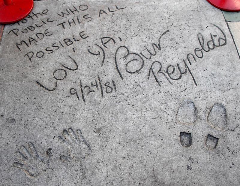 US actor Burt Reynolds wrote 'To the Public who made this all Possible, Lov Ya,' during his hand and foot prints in cement ceremony on 24 September 1981 at the TCL Chinese Theatre  in Hollywood.  EPA