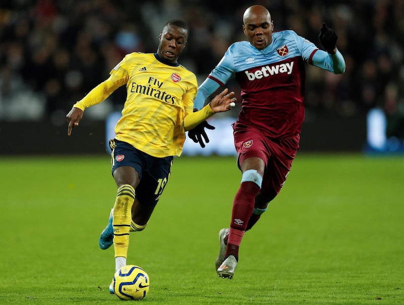 Arsenal midfielder Nicolas Pepe vies with West Ham United defender Angelo Ogbonna. AFP