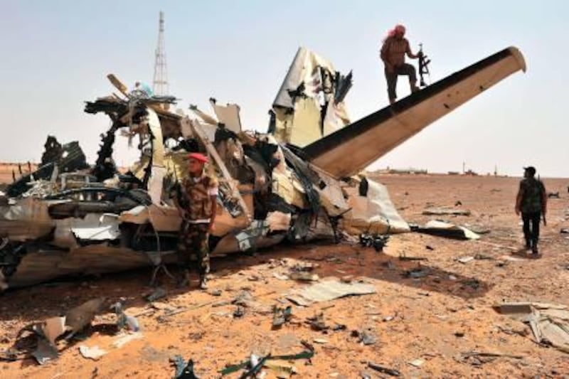 Rebels inspect an airplane destroyed by a NATO air strike at the Bir Durfan military base close to Bani Walid, on September 4, 2011. A special envoy for UN Secretary General Ban Ki-moon arrived in Libya as Libya's National Transitional Council have stepped up efforts to bring order and democracy to the country. AFP PHOTO/Carl de Souza
 *** Local Caption ***  751028-01-08.jpg
