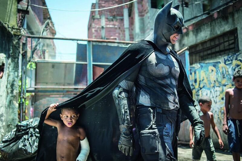 Children play around a man disguised as Batman at the Favela do Metro slum area just near the Maracana stadium, in Rio de Janeiro, Brazil, on January 9. Families living in this shantytown within a stone’s throw of Rio’s mythical Maracana stadium refuse to have their homes demolished as part of a project to renovate the district before the Fifa World Cup.  Yasuyoshi Chiba / AFP