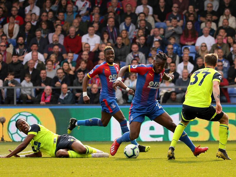 Crystal Palace's Michy Batshuayi, center, runs at Huddersfield Town's Erik Durm. PA via AP