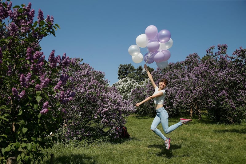 A woman jumps with balloons while she poses for a picture at a park in Kiev, Ukraine. Valentyn Ogirenko / Reuters