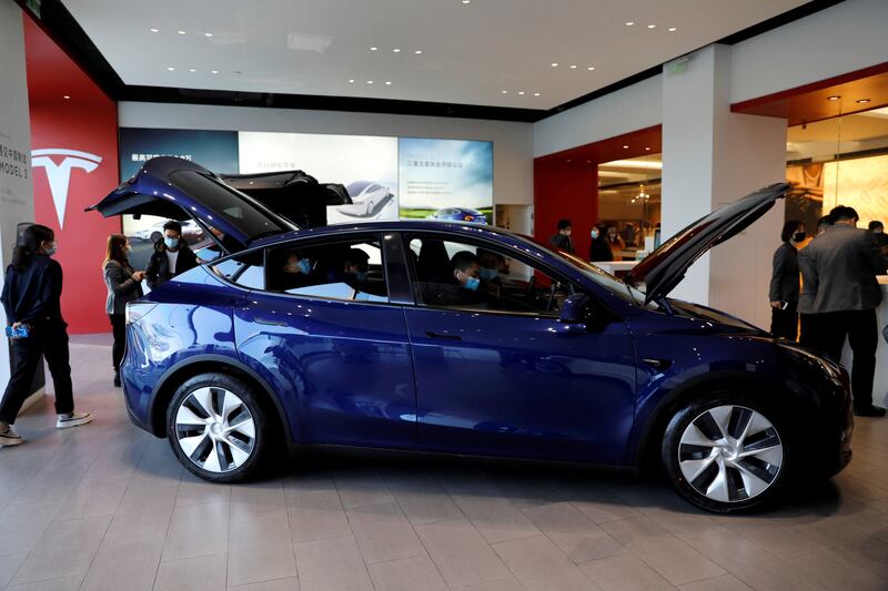 Visitors check a Tesla Model Y sports utility vehicle at the company's showroom in Beijing, China. Reuters