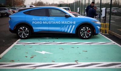 Workers plug in an electric Ford Mustang Mach-e electric vehicle at a press event at the Ford Halewood transmissions plant in Liverpool. Reuters 