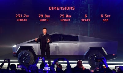 Tesla co-founder and CEO Elon Musk discusses vehicle dimensions in front of the newly unveiled all-electric battery-powered Tesla Cybertruck at Tesla Design Center in Hawthorne, California on November 21, 2019.  / AFP / Frederic J. BROWN
