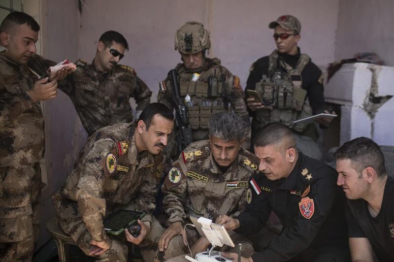Iraqi special forces officer Lt Gen Abdul Wahab Al Saadi, centre, and his team monitor ISIS positions in Mosul in June 2017. AP