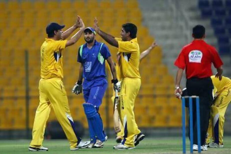 Asif Iqbal, right, of Danube Lions celebrates after dismissing the Sunny Patel, centre, of Yogi Group during the Ramadan Cup Finals at the Zayed Cricket stadium in Abu Dhabi on Thursday. Satish Kumar / The National