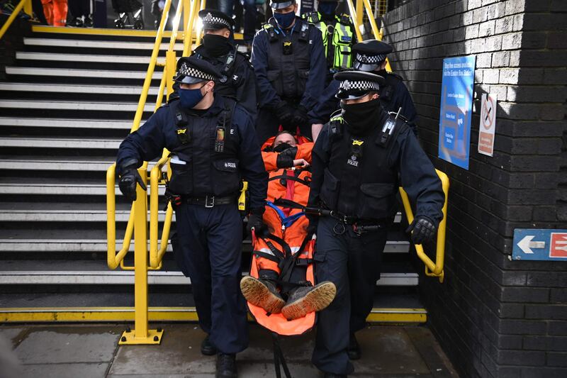 Police officers remove an activist from the roof of the HS2 office in central London. AFP