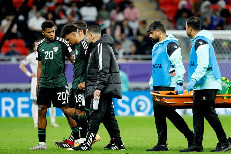 UAE forward Yahya Al Ghassani, left, escorts his midfielder Abdullah Ramadan off the pitch following the latter's injury. AFP