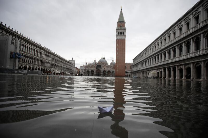 A boat made with a paper sheet floats in a flooded St. Mark's Square at Venice. AP Photo