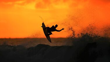 A surfer warms up at sunrise ahead of the Rip Curl Pro Bells Beach competition in Winkipop, Victoria, Australia. Getty Images