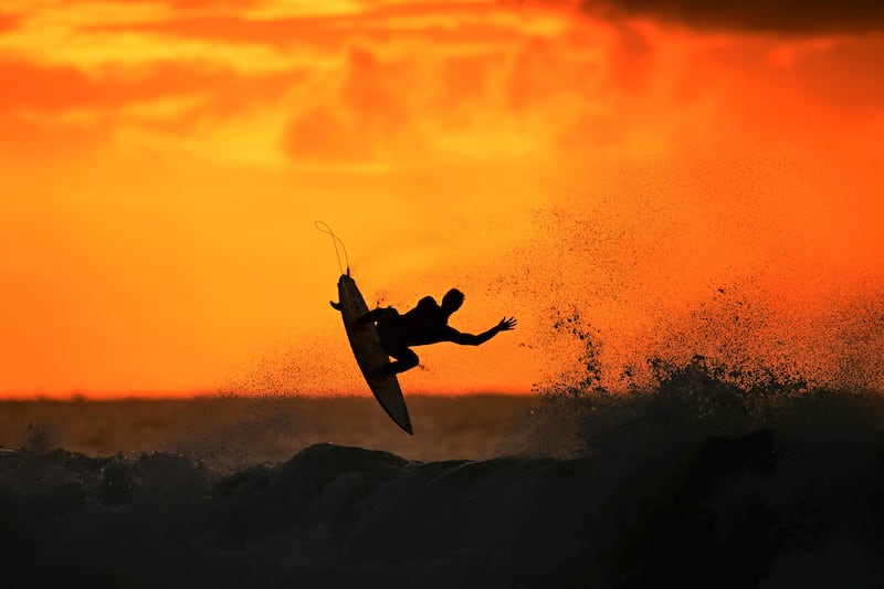 A surfer warms up at sunrise ahead of the Rip Curl Pro Bells Beach competition in Winkipop, Victoria, Australia. Getty Images