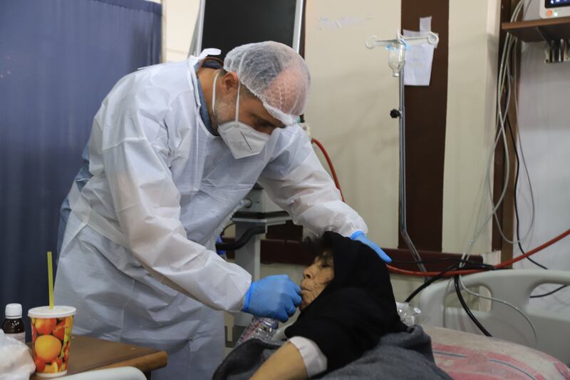 A nurse helps one of the patients to drink water. Abd Almajed Alkarh for The National