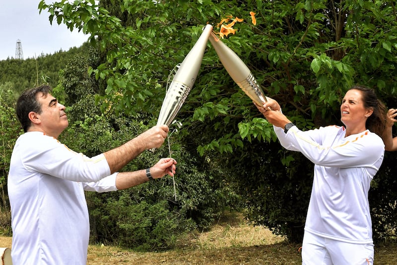 Manaudou lights the torch of the third torchbearer vice-president of the European Commission, Margaritis Schinas. Reuters
