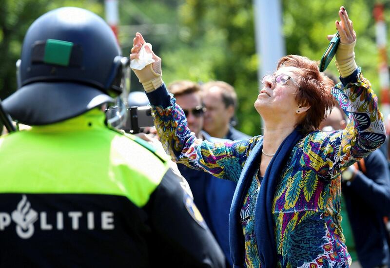 A woman gestures as she takes part in a protest against social-distancing measures, in The Hague, Netherlands. Reuters