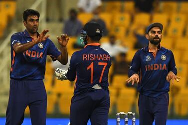 India's Ravichandran Ashwin (L) celebrates with teammate Rishabh Pant after taking the wicket of Afghanistan's Gulbadin Naib (not pictured) as India's captain Virat Kohli (R) watches during the ICC men’s Twenty20 World Cup cricket match between India and Afghanistan at the Sheikh Zayed Cricket Stadium in Abu Dhabi on November 3, 2021.  (Photo by INDRANIL MUKHERJEE  /  AFP)