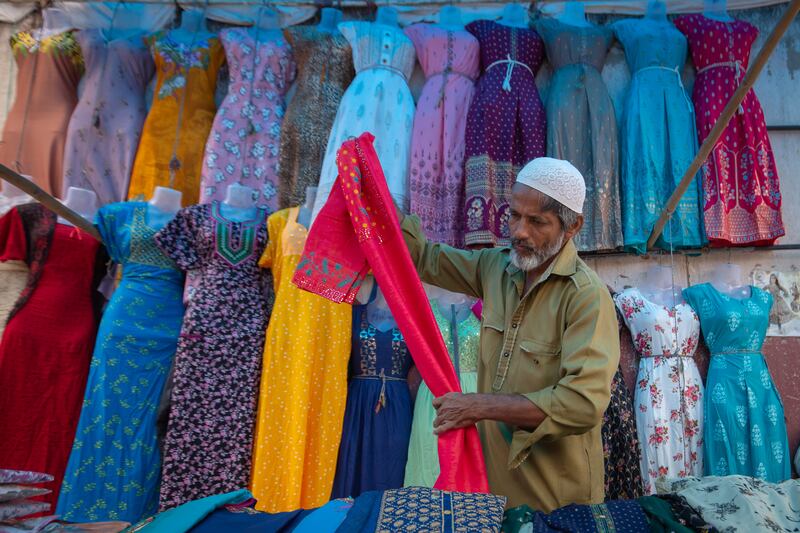 A Muslim cloth seller arranges his wares on a pedestrian pavement in Bengaluru, India. Getty Images