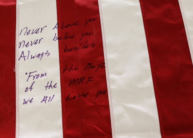 Messages written on a flag-draped coffin of one of the killed service members. Reuters