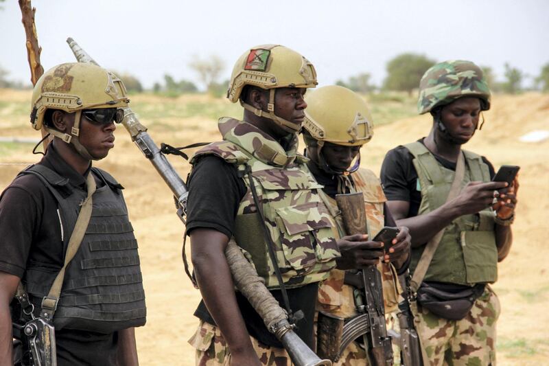 Nigerian Army soldiers stand at a base in Baga on August 2, 2019. - Intense fighting between a regional force and the Islamic State group in West Africa (ISWAP) has resulted in dozens of deaths, including at least 25 soldiers and more than 40 jihadists, in northeastern Nigeria. ISWAP broke away from Boko Haram in 2016 in part due to its rejection of indiscriminate attacks on civilians. Last year the group witnessed a reported takeover by more hardline fighters who sidelined its leader and executed his deputy. The IS-affiliate has since July 2018 ratcheted up a campaign of attacks against military targets. (Photo by AUDU MARTE / AFP)