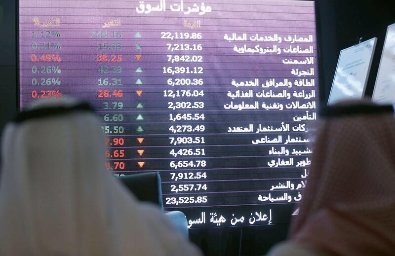 Saudi investors monitor stocks at the newly opened exchange market department at the National Commercial  Bank (NCB) in Riyadh on November 12, 2014. NCB shares surged 10 per cent in their first day of trading after the kingdom’s largest public offering.  It raised $6 billion and was oversubscribed 23 times. AFP PHOTO/FAYEZ NURELDINE