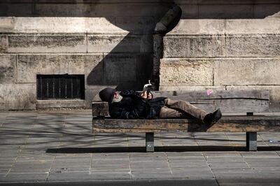 A  man read a book on a bench in Paris, on March 31, 2020 on the fifteenth day of a lockdown aimed at stopping/curbing the spread of the COVID-19 (novel coronavirus).  / AFP / JOEL SAGET
