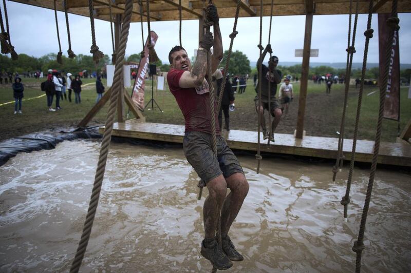 Runners take part in 'The Mud Day challenge', a 13-kilometre obstacles course, on in Beynes near Paris, on Saturday. Martin Bureau / AFP