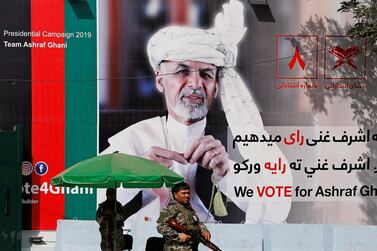 A member of the Afghan security force stands in front of a poster of Afghan presidential candidate Ashraf Ghani in Kabul, Afghanistan. Reuters