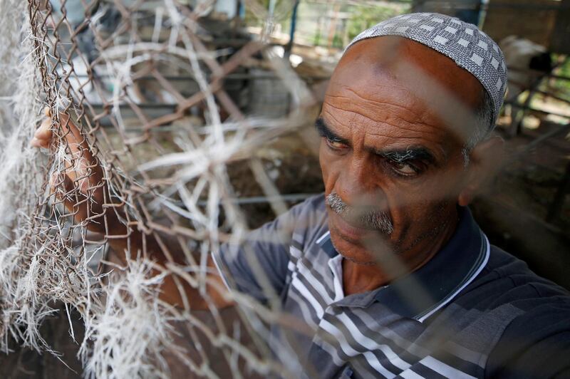 A Palestinian man stands by a fence at the site of an Israeli airstrike in Gaza City. Reuters