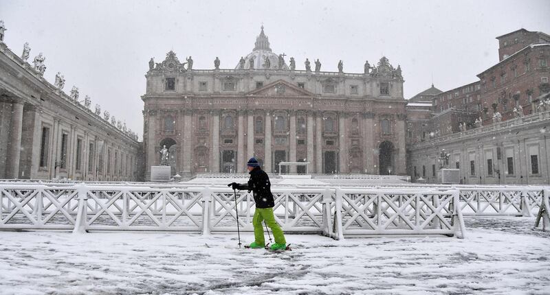 A man skis past St Peter's Square covered in snow on February 26, 2018  at The Vatican. Tiziana Fabi / AFP