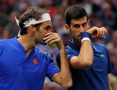 Team Europe's Roger Federer, left, whispers to Novak Djokovic during a men's doubles tennis match against Team World's Jack Sock and Kevin Anderson at the Laver Cup, Friday, Sept. 21, 2018, in Chicago. (AP Photo/Jim Young)
