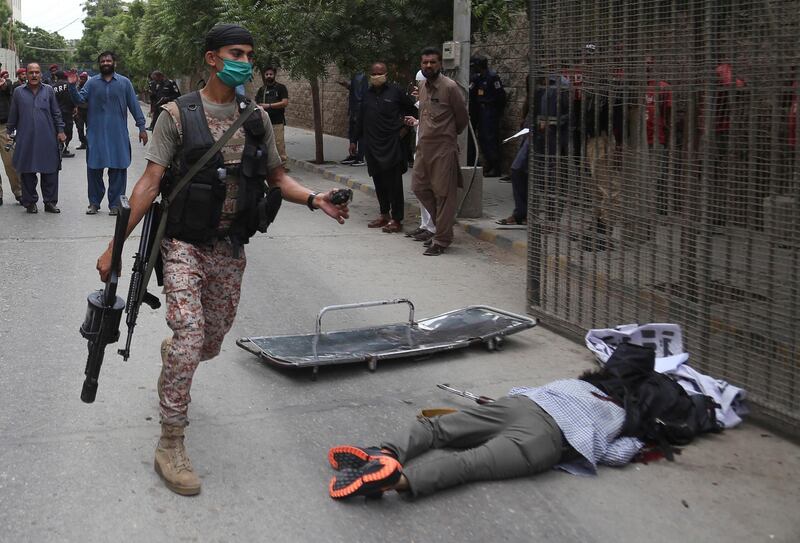 epa08515327 The body of a gunmen at the scene of an attack by unknown gunmen at Karachi Stock Exchange in Karachi, Pakistan, 29 June 2020. At least four gunmen and two civilians were reportedly killed and security forces have cordoned off the area as fighting is currently ongoing.  EPA/REHAN KHAN