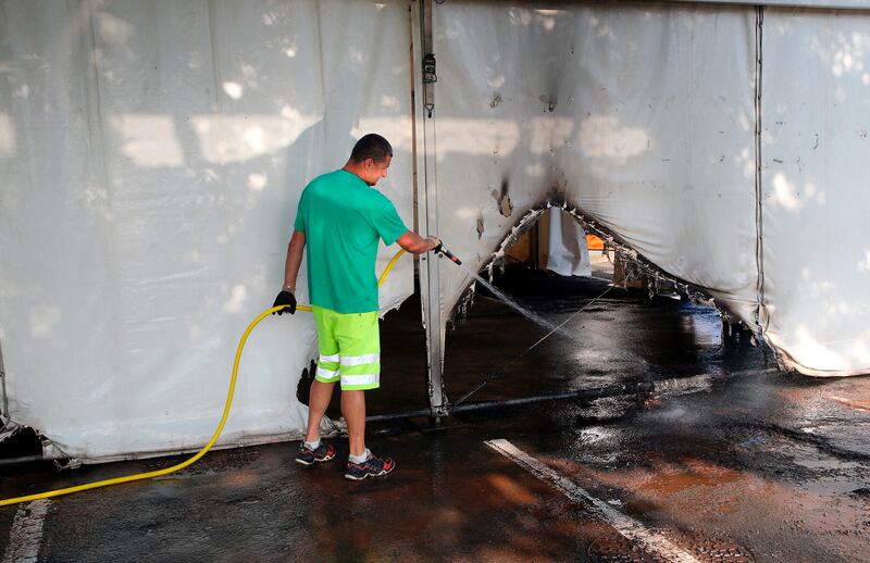 A municipality worker cleans debris from a burnt Covid-19 vaccination center in Urrugne, south-western France. The centre was the target of an arson attack.