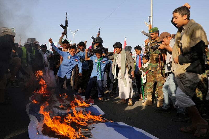 Israeli and US flags are burned at a rally in Sanaa, Yemen, as Houthi leaders denounced air strikes launched by America and Britain against the rebels. Reuters