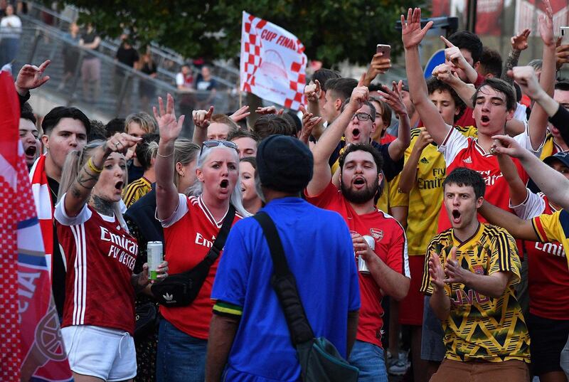 Arsenal fans and a lone Chelsea supporter  outside the Emirates stadium. AFP