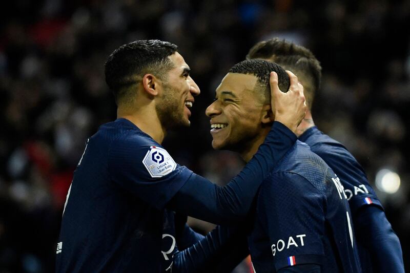 Kylian Mbappe celebrates with Achraf Hakimi after scoring a penalty for PSG against Strasbourg. AFP