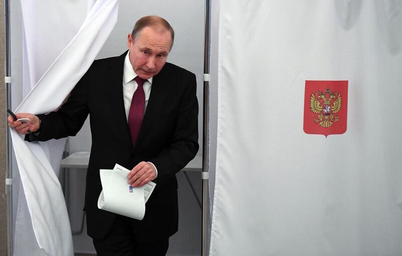 TOPSHOT - Presidential candidate, President Vladimir Putin walks out of a voting booth at a polling station during Russia's presidential election in Moscow on March 18, 2018. / AFP PHOTO / POOL / Yuri KADOBNOV