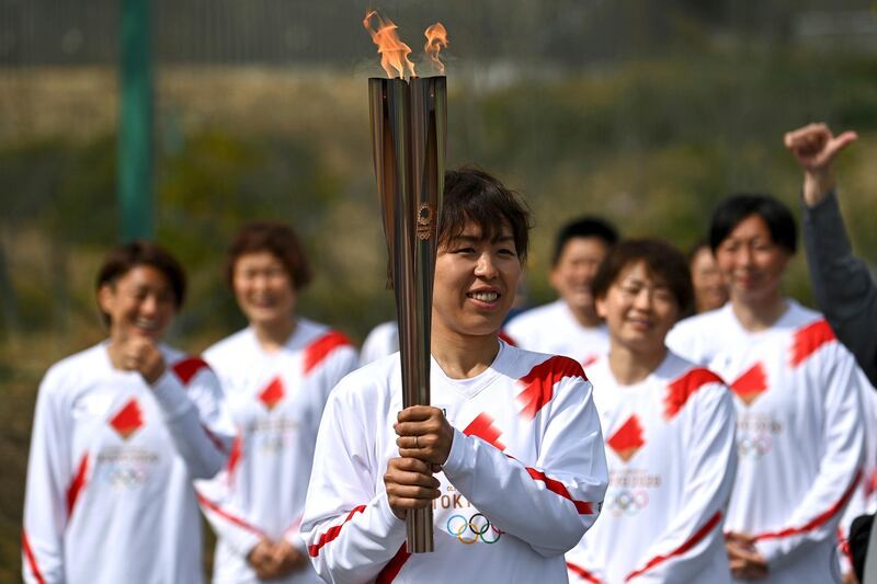 Japan footballer Azusa Iwashimizu arrives to pass on the flame. AP