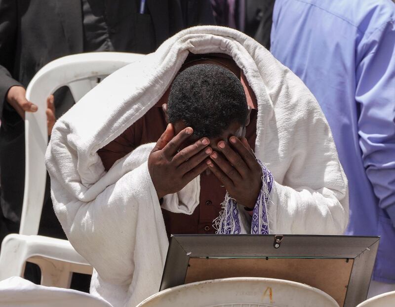 A mourner cries as he looks at a photo of the co-pilot during a memorial. Getty Images