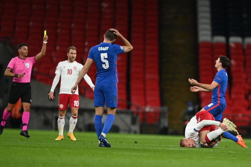 Referee Jesús Gil Manzano shows a yellow card to Maguire after his tackle on Dolberg. AFP