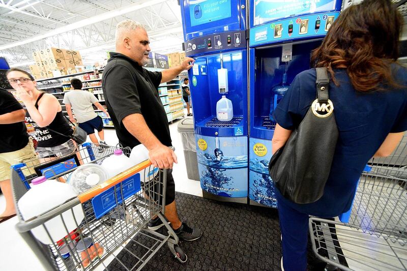 A resident refills water bottles at a Wal-Mart Super Store. AFP