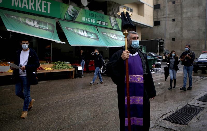 A Lebanese Maronite Christian priest leads a prosession in a street on Good Friday, in the dominantly Christian suburb of Dekwaneh, east of the capital Beirut. AFP