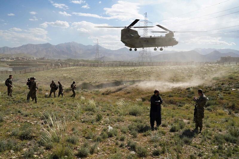 In this photo taken on June 6, 2019, a US military Chinook helicopter lands on a field outside the governor's palace during a visit by the commander of US and NATO forces in Afghanistan, General Scott Miller, and Asadullah Khalid, acting minister of defense of Afghanistan, in Maidan Shar, capital of Wardak province. A skinny tangle of razor wire snakes across the entrance to the Afghan army checkpoint, the only obvious barrier separating the soldiers inside from any Taliban fighters that might be nearby. - To go with 'AFGHANISTAN-CONFLICT-MILITARY-US,FOCUS' by Thomas WATKINS
 / AFP / THOMAS WATKINS / To go with 'AFGHANISTAN-CONFLICT-MILITARY-US,FOCUS' by Thomas WATKINS
