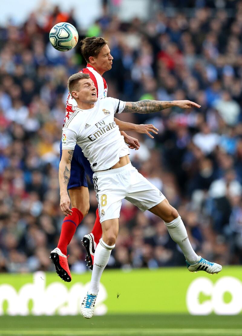 Marcos Llorente of Atletico Madrid wins a header over Toni Kroos of Real Madrid on Saturday. Getty Images